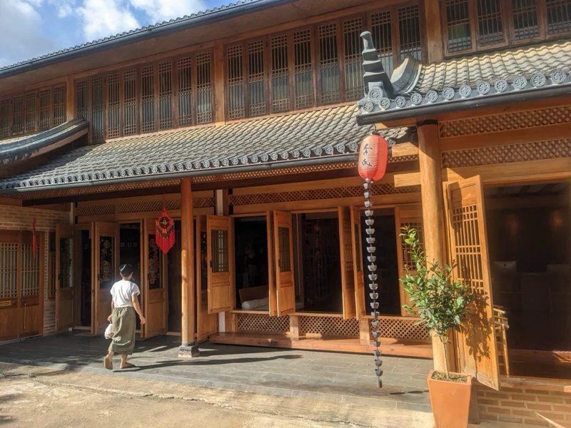 伝統的な日本家屋の入り口に立つ人